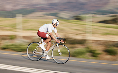 Image showing Cycling, fitness and man with bike on road, speed and action with motion blur of cyclist outdoor and helmet for safety. Mockup space, athlete and training for race, exercise in nature with bicycle