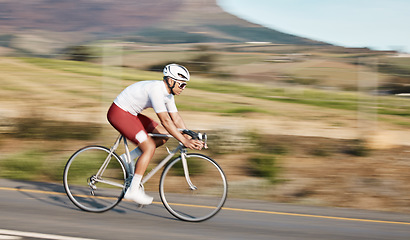 Image showing Cycling, exercise and man with bike on road, speed and action with motion blur of cyclist outdoor and helmet for safety. Mockup space, athlete and training for race, fitness in nature with bicycle