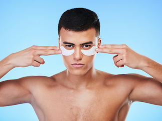 Image showing Man, beauty and face with eye patch for skincare, grooming and clean with hygiene isolated on blue background. Skin treatment, cosmetics product and wellness, portrait and dermatology in a studio