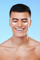 Image showing Man, beauty and face with lotion on skin, moisturizer and grooming for hygiene isolated on blue background. Sunscreen, cream and dermatology, skincare and treatment with cosmetics product in a studio