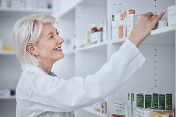 Image showing Happy senior woman, pharmacist and inventory on shelf for inspection or checking stock at drugstore. Mature female medical or healthcare professional smile in medication or pharmaceutical at pharmacy