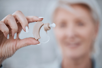 Image showing Hand, closeup and hearing aid with senior woman for audio, sound or listen with healthcare in retirement. Elderly lady, deaf or person with disability holding technology for ear implant for wellness