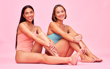 Image showing Diversity, swimwear and portrait of women in studio, sitting together with smile and fun body positivity. Beauty, summer fashion and happy bikini models with self love, equality and pink background.