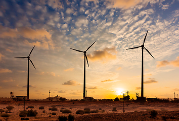 Image showing Wind generator turbines sihouettes on sunset