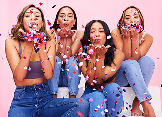 Image showing Blow, fashion and women in studio with confetti for celebration, clothing sale and discount. Beauty, diversity and female people on pink background for cosmetics, trendy clothes and denim outfit