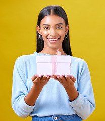 Image showing Woman, winner portrait and gift box, offer and prize for giveaway or shopping on yellow background. Happy person with present and ribbon package for retail sale, winning or competition in studio