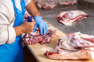 Image showing Butcher cutting fresh meat