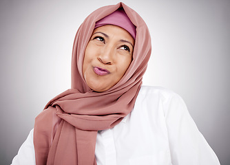 Image showing Smile, pouting and a Muslim woman on a studio background with hijab for happiness. Funny, thinking and a mature Islamic person or model with an expression for comedy, goofy or silly on a backdrop