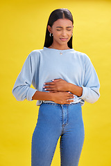 Image showing Sick, stomach pain and woman with constipation, digestion problem or diarrhea in studio isolated on a yellow background. Abdomen gas, disease and person with menstrual cramps, endometriosis or hernia