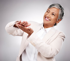 Image showing Smile, money gesture and senior woman in a studio with cashback, prize or financial freedom. Happy, excited and elderly female model with finance hand sign or emoji for savings by a gray background.