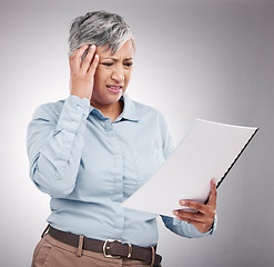 Image showing Problem, mature and a woman with a report on a studio background for planning of business with stress. Headache, corporate and a manager or employee reading a document with a mistake or frustrated