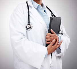 Image showing Tablet, technology and hands of doctor in studio for healthcare services, telehealth support and help. Closeup of medical worker, digital connection and consulting clinic research on gray background