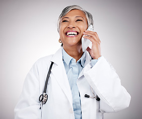 Image showing Phone call, doctor and woman in studio for happy conversation, medical consulting or telehealth contact. Mature surgeon, laugh or talk on mobile in communication, support or advice on gray background