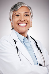 Image showing Woman, portrait and doctor with arms crossed in studio for healthcare services, smile and consulting. Happy mature surgeon, expert therapist and medical professional with trust on gray background