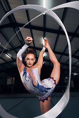 Image showing Woman, portrait and balance for ribbon gymnastics in competition, performance or concert in dark arena. Flexible dancer, rhythm and agile athlete training with talent, creative contest or sports show