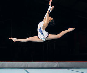 Image showing Fitness, jump and performance with a dance woman in a gym for training or practice for a competition. Exercise, event and energy with a young female gymnastic or rhythmic dancer in a workout studio