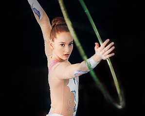 Image showing Dance, concert with a gymnastics hoop and a woman in the gym for a performance showcase or practice. Training, energy and fitness with a female athlete on a dark background for routine or recital