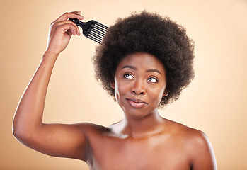Image showing Afro, hair care and black woman in studio with comb for wellness, beauty and salon hairstyle. Haircare, treatment and happy African girl with curls, tools and beige background for luxury spa routine.