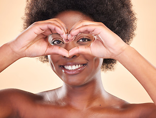 Image showing Smile, portrait and a black woman with heart hands on a studio background for love or support. Happy, emoji and face of African girl or model with a sign or gesture for care or kindness on a backdrop