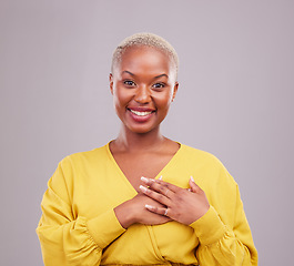 Image showing Gratitude, happy and portrait of a black woman in a studio with sweet, kind and positive attitude. Empathy, grateful and young African female model with thank you gesture isolated by gray background.