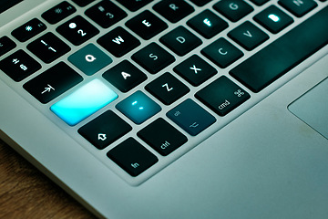 Image showing Laptop, keyboard and shift key glow on a desk closeup for networking, typing or blogging in an office. Computer, technology and email connection with futuristic web browsing on a table from above