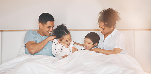 Image showing Happy, tickle and relax with family in bedroom for playful, morning and love. Care, support and wake up with parents and children laughing in bed at home for weekend, positive and resting together