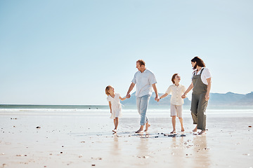 Image showing Travel, walking and family holding hands at the beach on vacation, holiday or adventure together. Bonding, fun and children with their mother and father by the ocean for fresh air on a weekend trip.