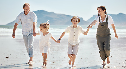 Image showing Adventure, running and family holding hands at the beach on vacation, holiday or weekend trip together. Bonding, fun and children playing with their mother and father by the ocean for fresh air.