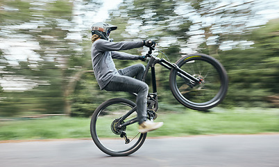 Image showing Bike, man and balance on wheel in nature for competition, challenge and adventure of motion in road. Cycling, sports race and fast action on bicycle for performance, energy with power, speed and risk