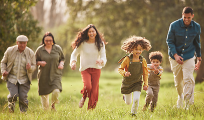 Image showing Family, park and parents running with children in nature for playing, bonding and fun together in field. Happy grandparents, mom and father with kids relax outdoors on holiday, freedom and vacation