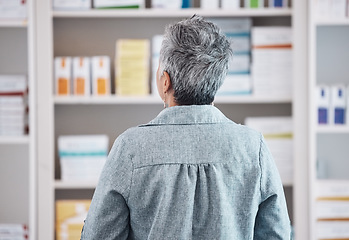 Image showing Patient, pharmacy and checking pharmaceutical shelf for medication, healthcare or boxes at the drugstore. Rear view of customer in search for medical product, supplements or antibiotics at the clinic
