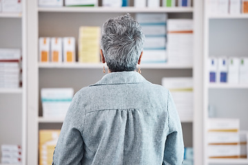 Image showing Back, senior woman and pharmacy, shopping for pills with dispensary, sick and health with wellness. Medicine, antibiotic for healthcare and search shelf, pharmaceutical drugs and patient in drugstore