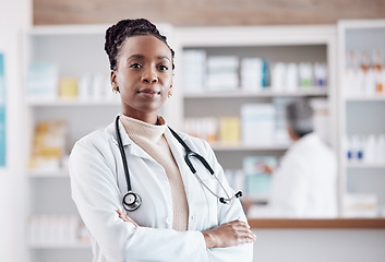 Image showing Pharmacy, pharmacist or portrait of black woman with arms crossed in healthcare clinic or drugstore. Proud nurse, wellness or confident African doctor by medication or medicine on shelf ready to help