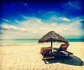 Image showing Two lounge chairs under tent on beach