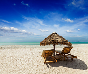 Image showing Two beach lounge chairs under tent