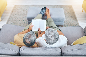 Image showing Relax, retirement and a senior couple reading a book on a sofa in the living room of their home from above. Love, storytelling and elderly people taking a break to study for knowledge or a hobby