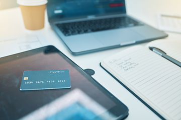 Image showing Desk, technology and a credit card with a notebook for work, planning business or finance. Closeup, ecommerce and notes for a corporate or accounting goal on a table for a payment on a tablet or pc