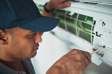 Image showing Face, hand and a man for aircon repair or maintenance in an office for circulation or central heating. Construction, tools or screwdriver with an engineer working on an air conditioning unit closeup