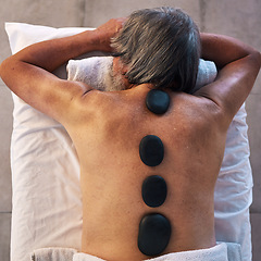 Image showing Hot stone massage and back of man in spa for wellness, holistic treatment and hospitality. Peace, cosmetics and beauty salon with body of customer at hotel for relax, vacation and physical therapy