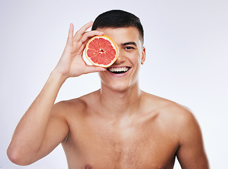 Image showing Beauty, grapefruit and skincare with portrait of man in studio for health, detox and natural cosmetics. Vitamin c, nutrition and spa with person and fruit on white background for self care and glow