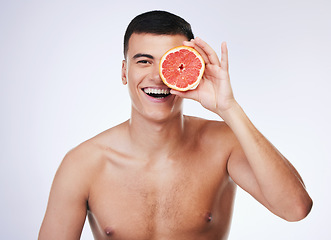 Image showing Beauty, grapefruit and health with portrait of man in studio for skincare, detox and natural cosmetics. Vitamin c, nutrition and spa with person and fruit on white background for self care and glow