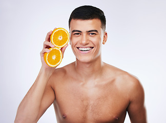 Image showing Skincare, orange and wellness with portrait of man in studio for health, detox and natural cosmetics. Vitamin c, nutrition and summer with face of person and fruit on white background for self care