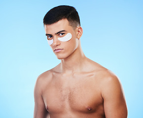 Image showing Man, beauty and portrait with eye patch for skincare, grooming and clean with hygiene on blue background. Skin treatment, cosmetics product and wellness, self care and dermatology in a studio