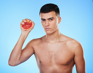 Image showing Squeeze, grapefruit and skincare with portrait of man in studio for health, detox and natural cosmetics. Vitamin c, nutrition and spa with person and fruit on blue background for self care and glow