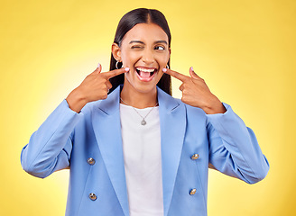 Image showing Fingers on cheek, smile and a happy woman in studio for positive attitude, dimples and emoji. Indian model person or student with fashion, comic and funny face or silly mood on a yellow background