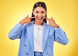 Image showing Fingers on cheek, portrait and a happy woman in studio for positive attitude, dimples and emoji. Indian model person or student with fashion, comic and excited face or silly mood on yellow background