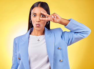 Image showing Business woman, peace sign and studio portrait with funny face, pouting and emoji by yellow background. Entrepreneur, hand and eye with kiss, comic face and icon for vote, opinion or crazy gesture