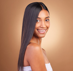 Image showing Portrait, hair care and woman with a smile, cosmetics and skincare on a brown studio background. Face, person and model with natural beauty, aesthetic and glow with dermatology, texture and volume