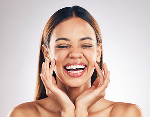 Image showing Self love, skincare and laughing woman with hands on face in studio for wellness, care or results on white background. Happy, beauty and female model excited for cosmetic, dermatology or glowing skin