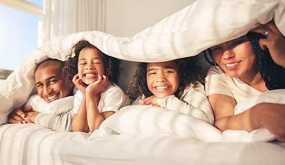 Image showing Happy family, bed and under blanket in home bedroom while comfortable, portrait and together. African woman, man and kids lying with cover for security, wake up and relax with mother and father